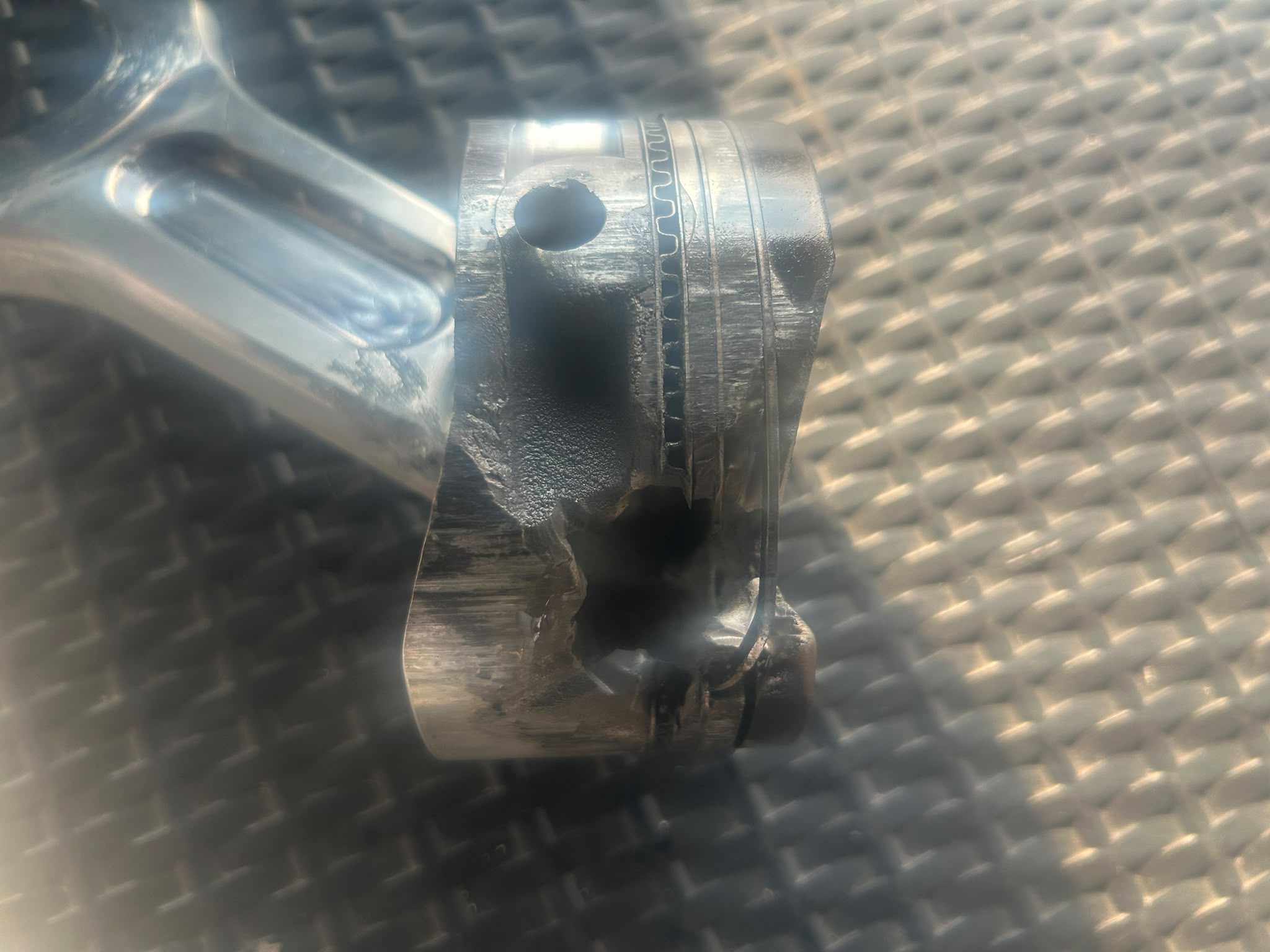 A hole melted into the side of the piston